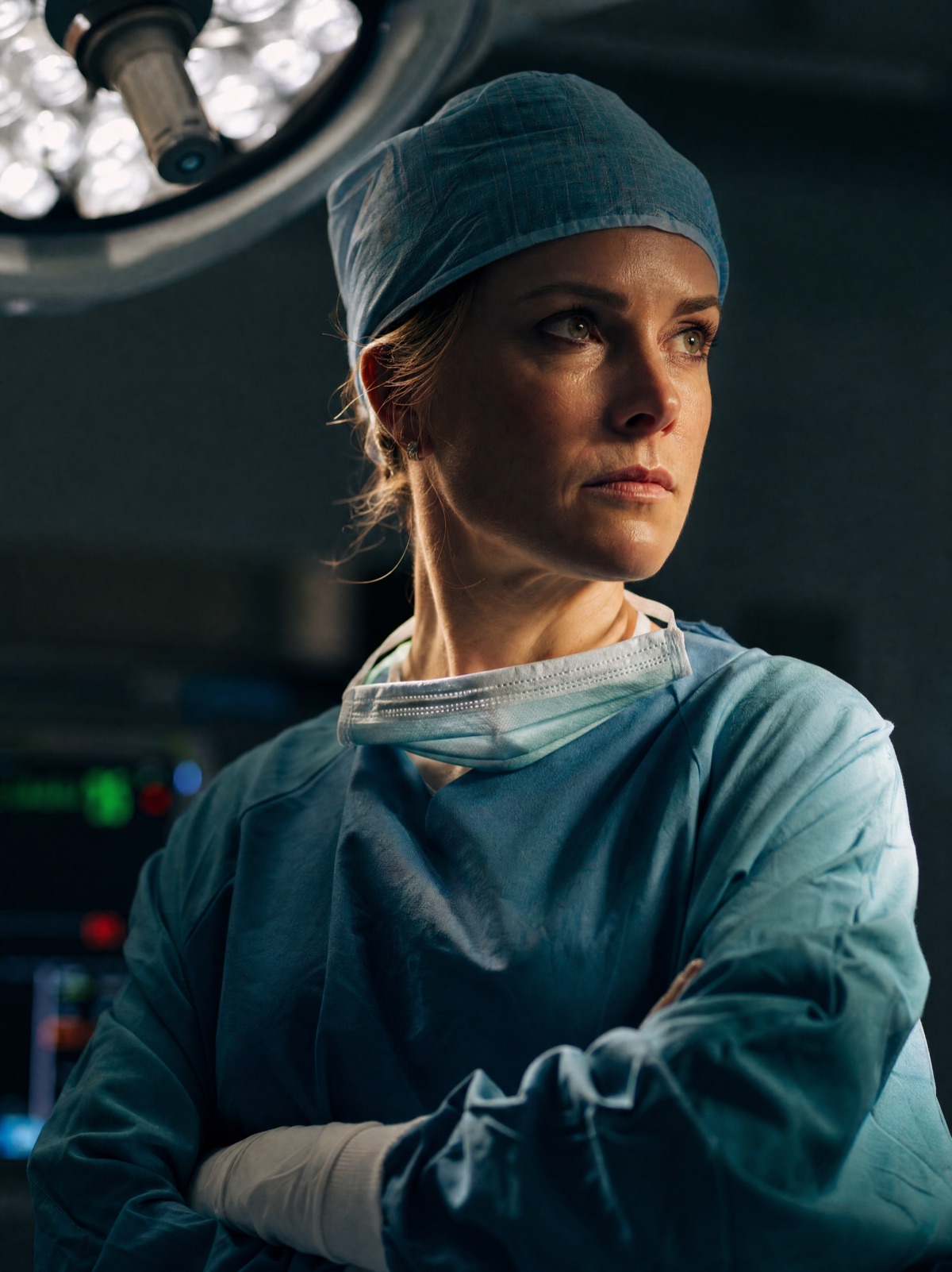 Surgeon in scrubs and cap in an operating room